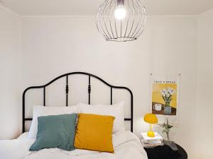 Un dormitorio con una cama blanca con almohadas amarillas y verdes en Liebe House en Seúl