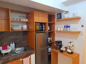 a kitchen with wooden cabinets and a stainless steel refrigerator at 2BR Condo in Tagaytay I Lake View I Fast Wifi I Free Parking in Tagaytay