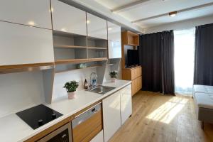 una cucina con armadi bianchi e lavandino di UPTOWN Hotel Apartments a Stoccolma
