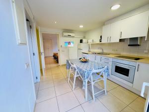 a kitchen with a table and a table and chairs at Trill Noray A bajos Estartit in L'Estartit