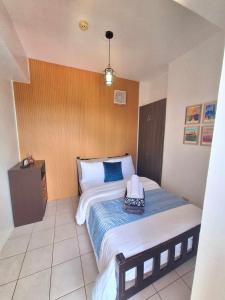 una camera da letto con un grande letto con una coperta blu di 2BR Condo in Tagaytay I Lake View I Fast Wifi I Free Parking a Tagaytay