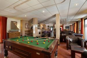 a living room with a pool table in a room at Hotel Amélie in Brides-les-Bains