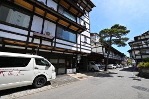 a white van parked in front of a building at Osakaya Ryokan in Kusatsu