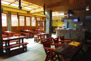 a restaurant with wooden tables and chairs and a bar at Chata u vinára Milana, Tatralandia in Liptovský Mikuláš