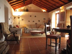a living room with a couch and a table and chairs at Casa Rural El Tabaibal in Hermigua