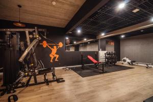 a gym with a man on the wall and weights at Caryńska Resort & SPA in Lutowiska