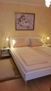1 cama blanca grande en una habitación con 2 lámparas en Agentur Bergblick, en Prien am Chiemsee