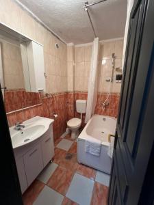 uma casa de banho com uma banheira, um WC e um lavatório. em Hotel Kuč em Budva