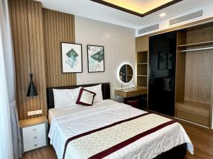 1 dormitorio con 1 cama grande y espejo en FLC Sea Tower Quy Nhơn - Codotel Cạnh Biển Quy Nhơn, en Quy Nhon