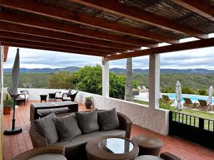 un patio con sofá, mesas y piscina en Monte Do Zambujeiro, en Vila Nova de Milfontes