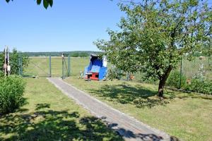 a park with a fence and a tree in a field at Ferienwohnungen in Baabe beim Fischer in Baabe