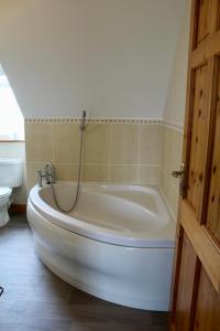 a white bath tub in a bathroom with a toilet at Mount Leinster View in Bunclody