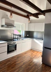 a kitchen with white cabinets and a stove top oven at 110 qm Stadtnahe Oase im Grünen in Priesendorf