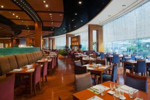 restauracja ze stołami i krzesłami oraz dużym oknem w obiekcie Holiday Inn Chengdu Century City West, an IHG Hotel w mieście Chengdu