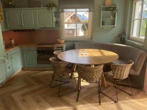 une cuisine avec une table et des chaises dans l'établissement Diamond Forest - 8 Full Beds Summercard Included, à Kaprun