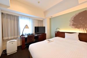 Hotel Keihan Sapporo في سابورو: غرفة فندقية فيها سرير ومكتب وتلفزيون