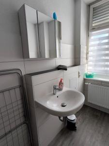 ein Badezimmer mit einem weißen Waschbecken und einem Spiegel in der Unterkunft Andrews Ferienwohnungen in Tangermünde