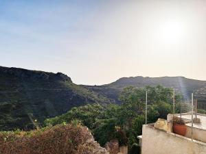 a view of a mountain from a house with trees at Levanta Apartment in Kythira