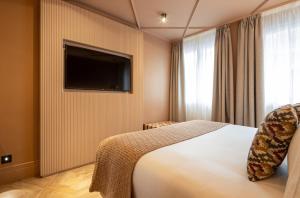 een hotelkamer met een bed en een flatscreen-tv bij Room Mate Leo in Granada