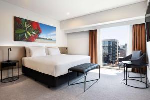 pokój hotelowy z łóżkiem i dużym oknem w obiekcie Travelodge Hotel Auckland Wynyard Quarter w Auckland