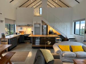 uma sala de estar com um sofá e uma cozinha em Featherstone View Cottage em Grahamstown