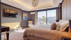 - une chambre avec un grand lit et une grande fenêtre dans l'établissement Imperia Luxury Residence, à Braşov