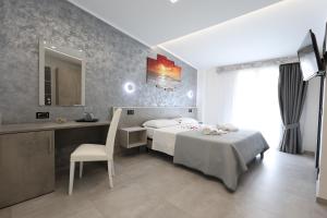 a bedroom with a bed and a desk and a mirror at B&B Sunlight Tropea in Tropea