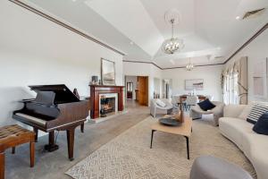sala de estar con piano y sofá en Sommerville Majestic Farm Manor Retreat 5bd 3Bth Pool Spa en Somerville