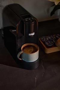 una macchinetta del caffè con una tazza di caffè di Wood Hotel Bodø a Bodø