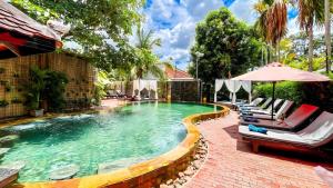 een zwembad met ligstoelen en een parasol bij Central Privilege Hotel in Siem Reap