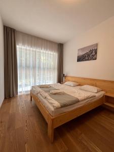 ein Schlafzimmer mit einem großen Bett vor einem Fenster in der Unterkunft Residence Post in Pec pod Sněžkou
