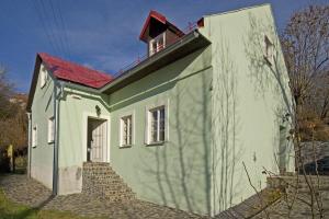 un petit bâtiment vert et blanc avec un toit rouge dans l'établissement Holiday Home Banská Štiavnica, à Banská Štiavnica