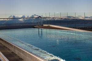 a swimming pool with a mountain in the background at Wood Hotel Bodø in Bodø