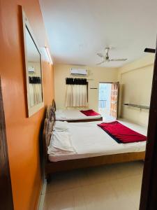 two beds in a room with a window at Hotel Raghunath residency -Niwas in Shirdi