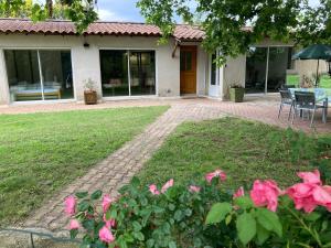 une maison avec une terrasse et des fleurs roses dans l'établissement Villa les Platanes Aix en Provence, à Aix-en-Provence
