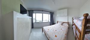 a bedroom with two bunk beds and a window at Apartamento Peruibe pé na areia!!! in Peruíbe