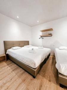 um quarto com duas camas e um candeeiro na parede em Alpha Hotel em Ostend