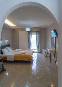 a bedroom with a bed and a desk and a window at Ermioni Rooms in Paralia Vrachou