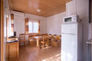 cocina con nevera blanca y mesa en Camping Sitges, en Sitges