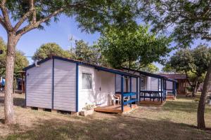een tiny house met een veranda en een terras bij Camping Sitges in Sitges