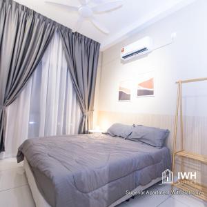 sypialnia z łóżkiem i wentylatorem sufitowym w obiekcie Ipoh Horizon Skypool Town Suites 4-11pax by IWH Suites w mieście Ipoh