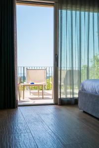 a bedroom with a sliding glass door to a balcony at Encanto Agriturismo & Private SPA in Visogliano