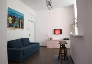 - un salon avec un canapé bleu et un tabouret dans l'établissement Attico e Suite Vistamare Vasto, à Vasto