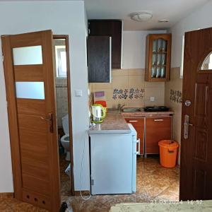 a kitchen with a white refrigerator and a sink at Camping Bałtyk in Dźwirzyno +30 photos