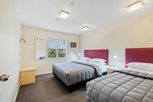 een slaapkamer met 2 bedden en een raam bij Tussock Peak Motor Lodge in Hanmer Springs