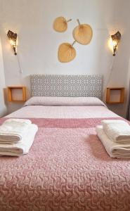 1 dormitorio con 1 cama con 2 almohadas en La Casa de Abuela, en Frigiliana