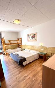 una camera d'albergo con due letti e un tavolo di Albergo Varone a Riva del Garda