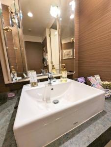 D-CUBE奈良店 في نارا: بالوعة بيضاء في الحمام مع مرآة