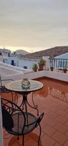 a patio with a table and chairs on a roof at LA CASA DE ABUELA Habitaciones con baño compartido en el casco histórico de Frigiliana "sólo adultos" in Frigiliana