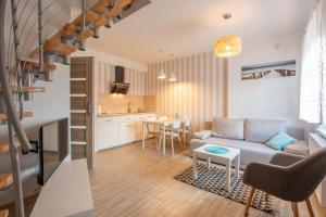 a living room with a couch and a table at Piaskowe Domki in Grzybowo
